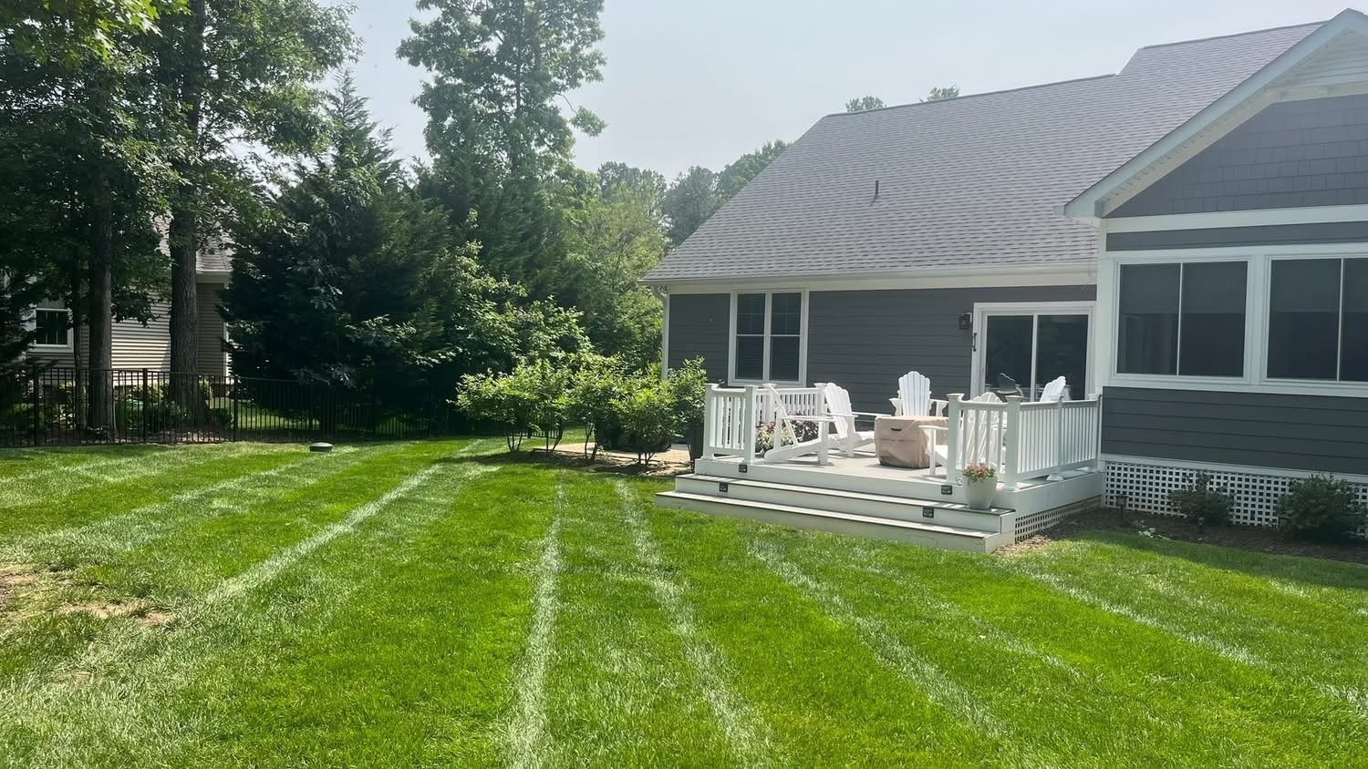 Tree-lined backyard with a neatly striped lawn