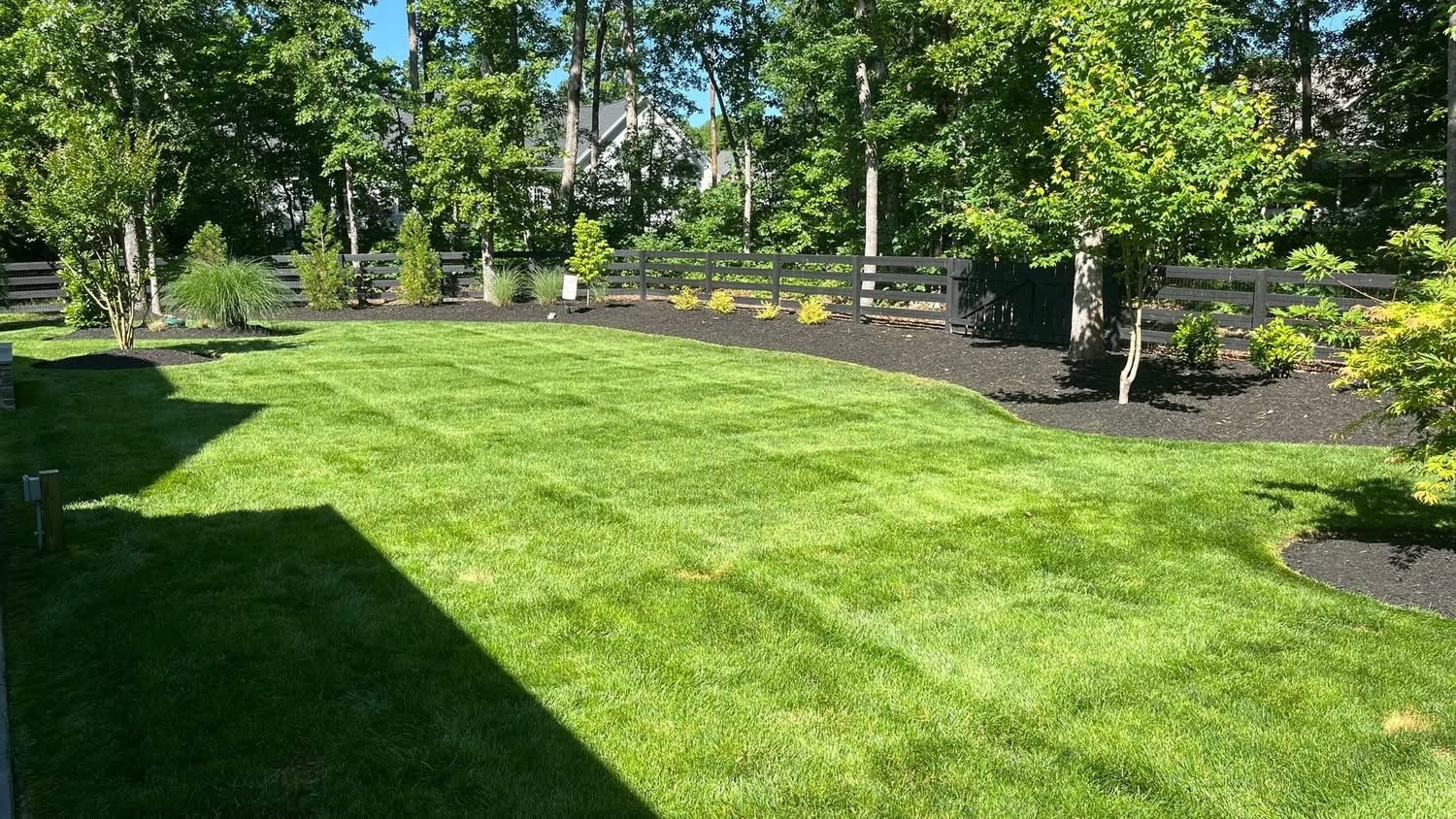 Lawn bordered by freshly mulched landscape beds